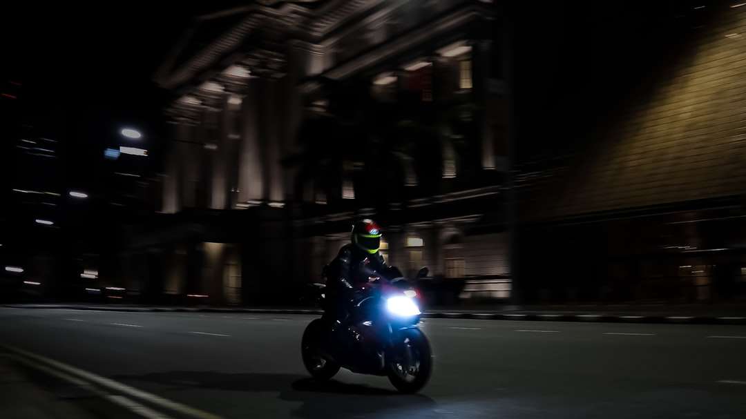 Uomo che guida la motocicletta sulla strada durante la notte puzzle online