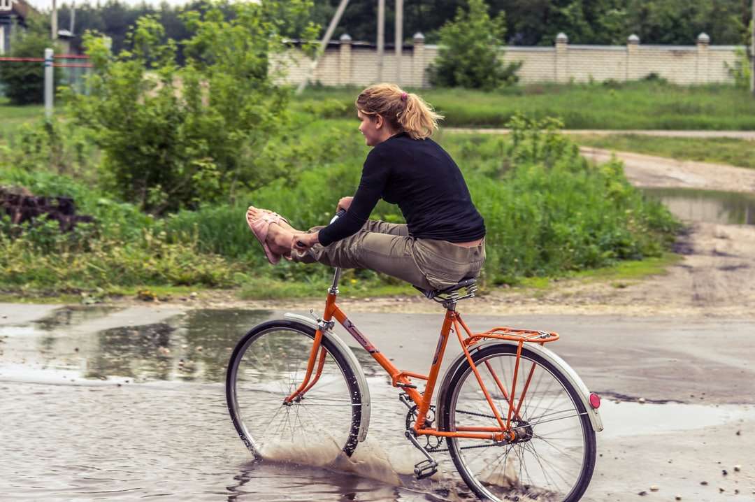 Frau im schwarzen langärmligen Hemd Reiten rotes Fahrrad Online-Puzzle