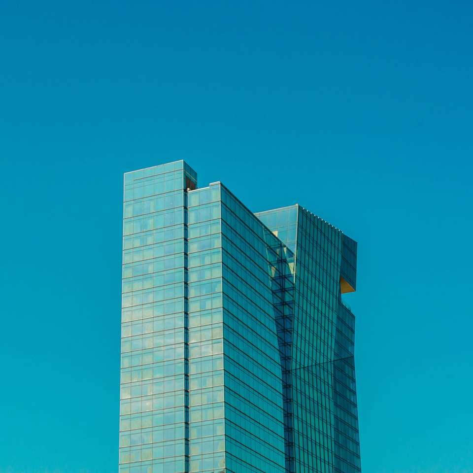 Clădire de beton alb și albastru sub cerul albastru puzzle online