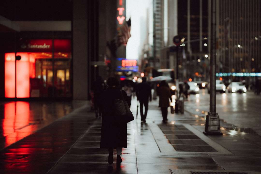 люди ходять по тротуару в нічний час пазл онлайн