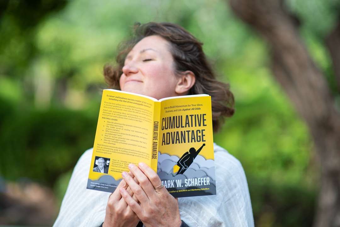 Γυναίκα σε λευκό πουκάμισο κρατώντας κίτρινο βιβλίο online παζλ