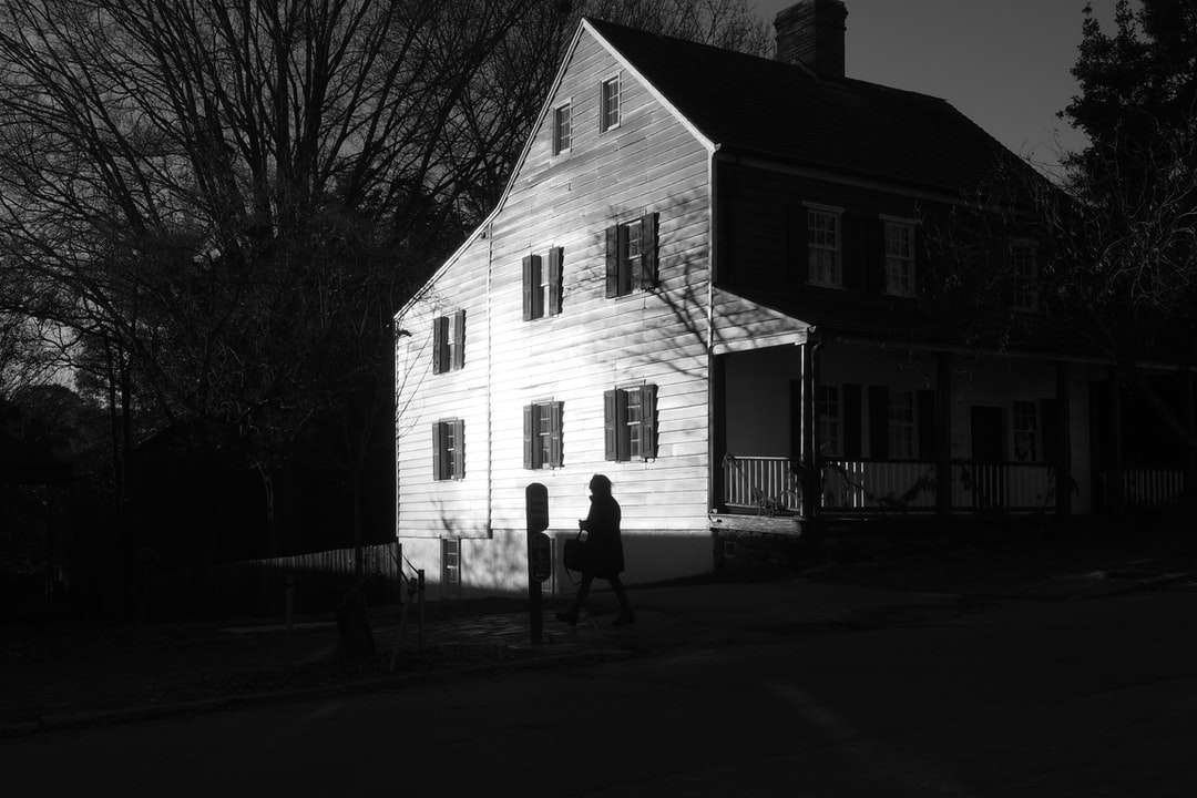 2 personer som står framför vitt och brunt hus Pussel online