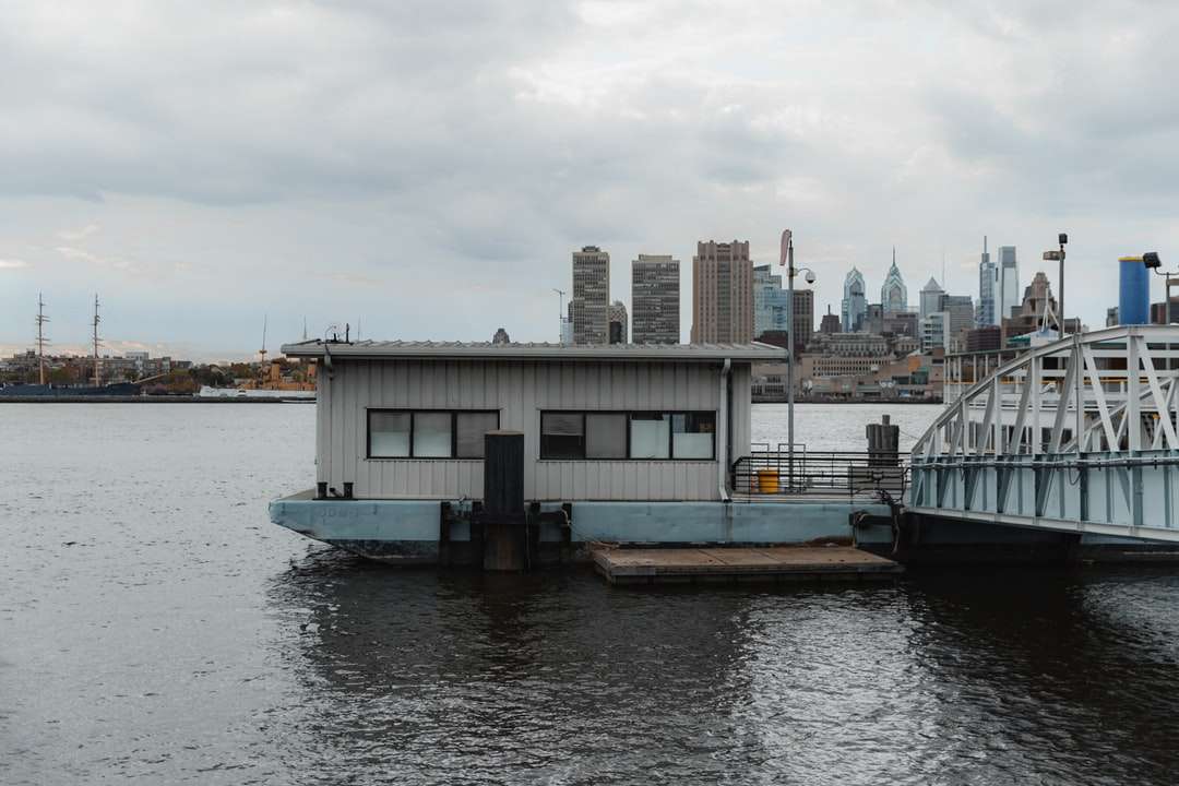 Bílá a černá loď na vodě v blízkosti městských budov online puzzle