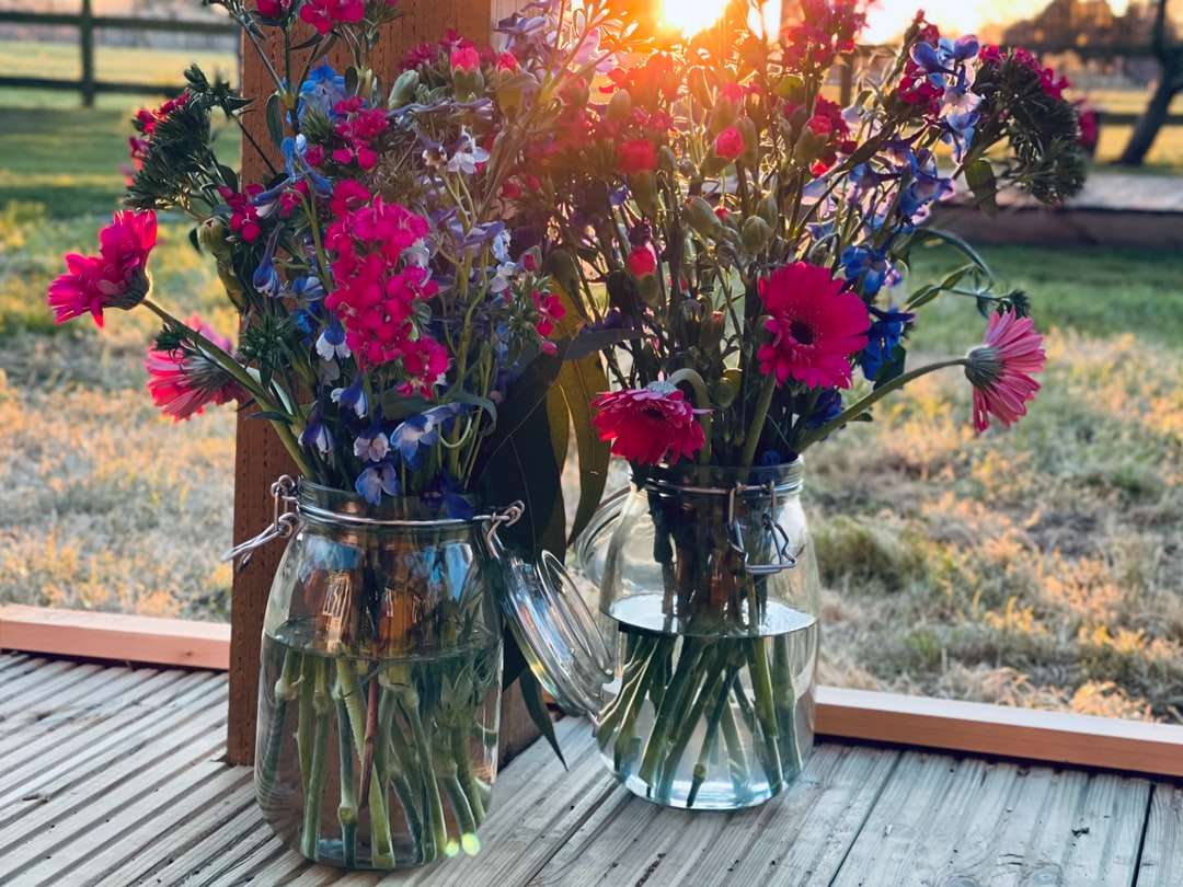 Piros és sárga virágok tiszta üveg vázában online puzzle