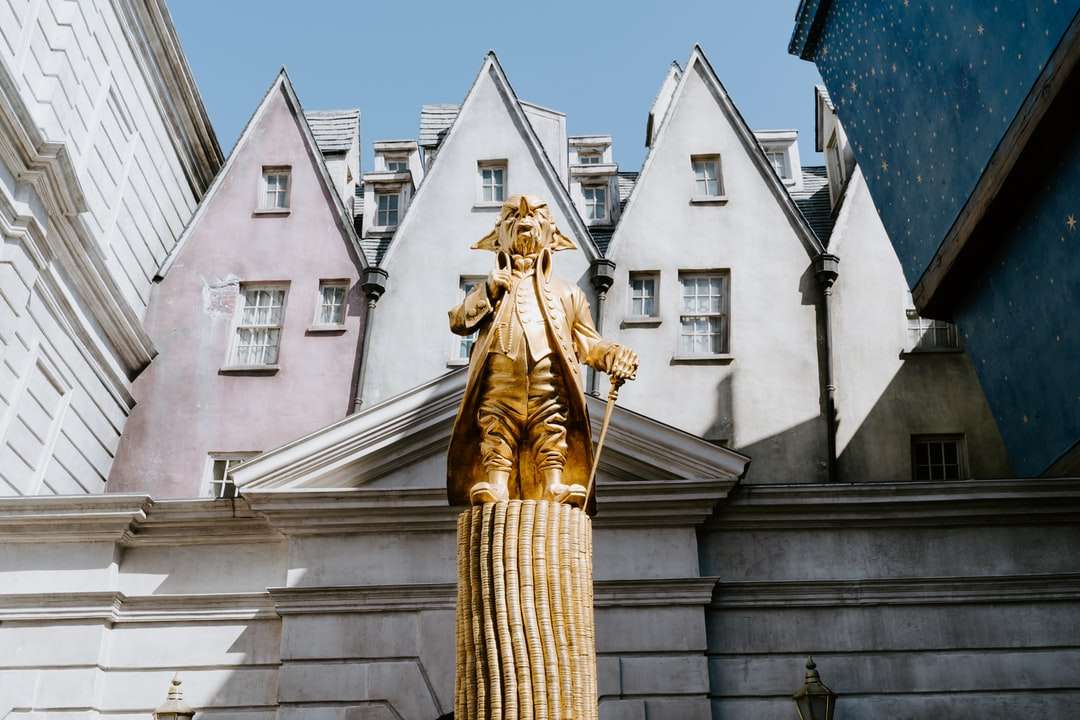 Златна статуя близо до бяла бетонна сграда през деня онлайн пъзел
