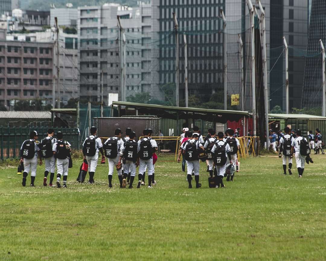 persone in uniforme bianca e nera sul campo di erba verde puzzle online