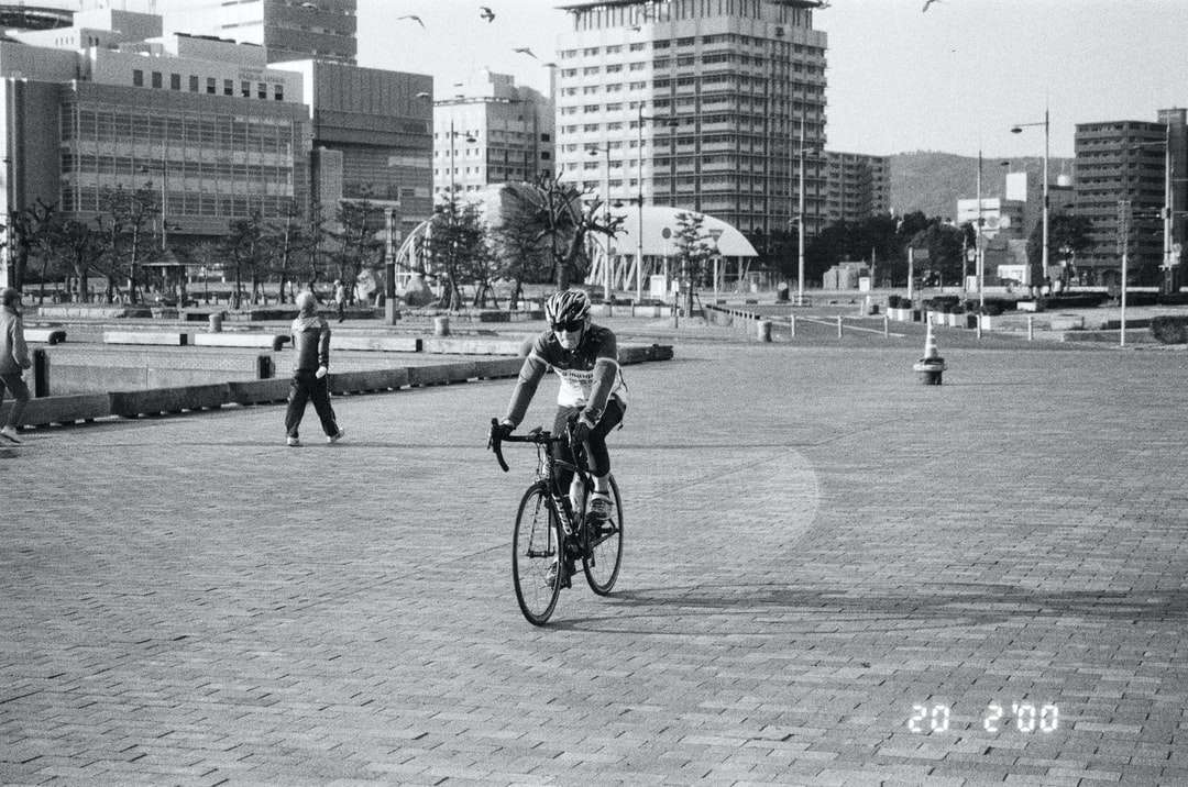 φωτογραφία κλίμακας του γκρι του ανθρώπου που οδηγεί ποδήλατο στο δρόμο online παζλ