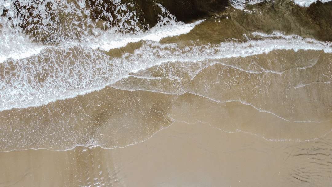 Watergolven op bruin zand online puzzel