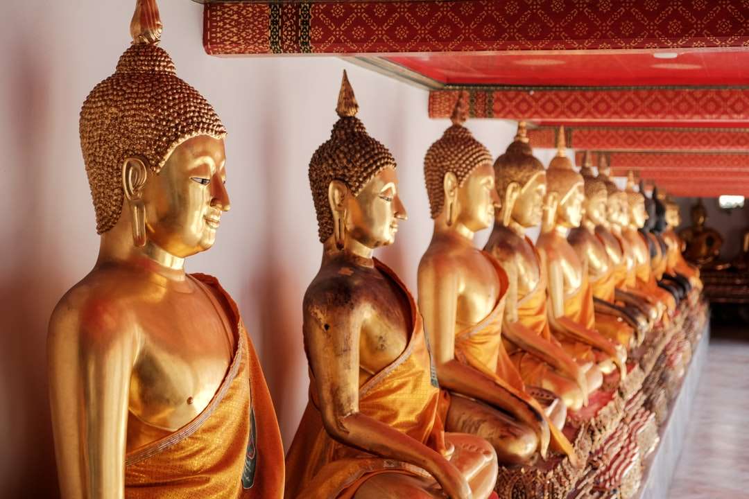 Zlatá socha Buddhy na červené a bílé textilní skládačky online