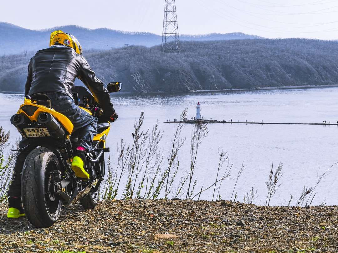 Man in zwart jasje rijden geel en zwarte motorfiets online puzzel