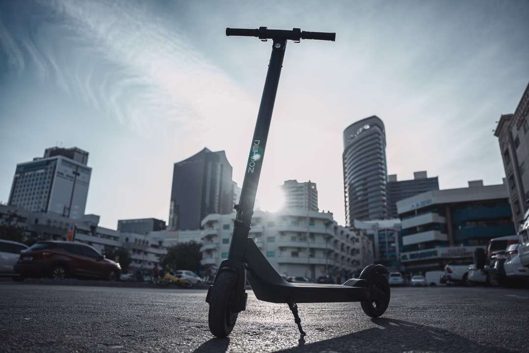 Черно велосипед близо до водна и градска сграда онлайн пъзел