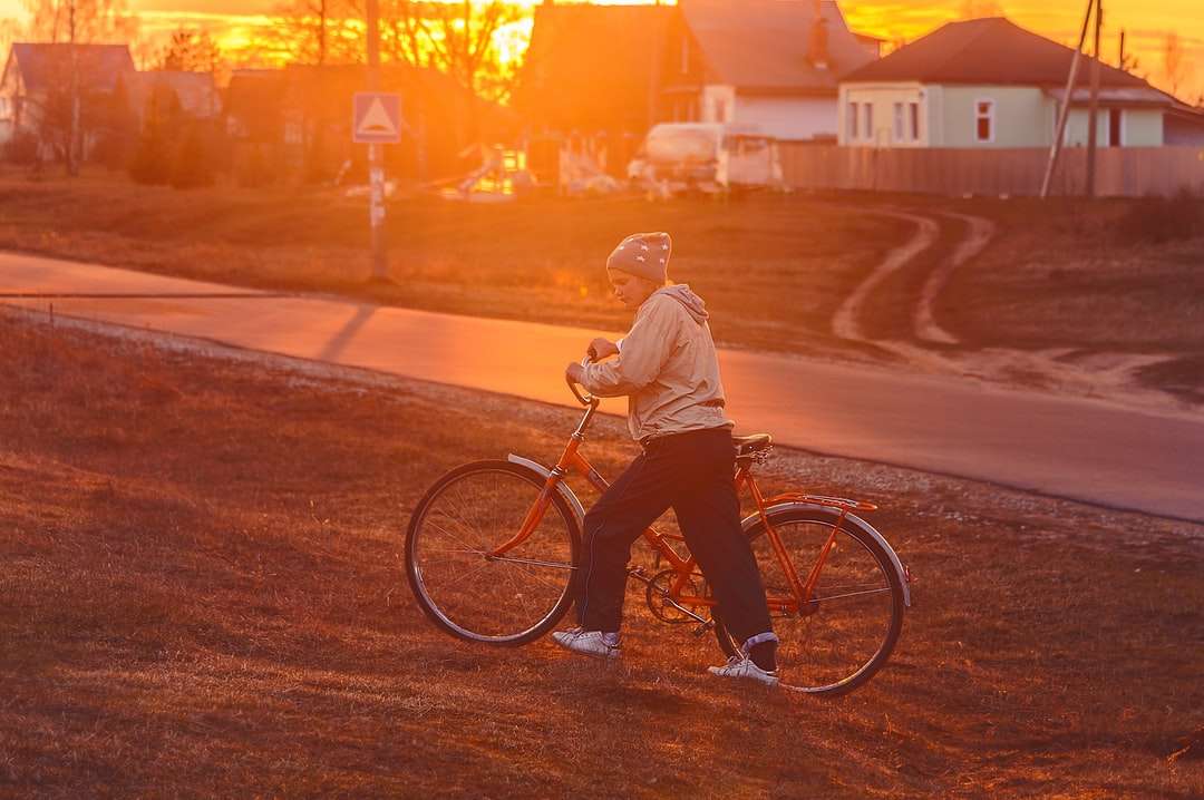 Mann in weißer Jacke, der während des Sonnenuntergangs Fahrrad fährt Online-Puzzle