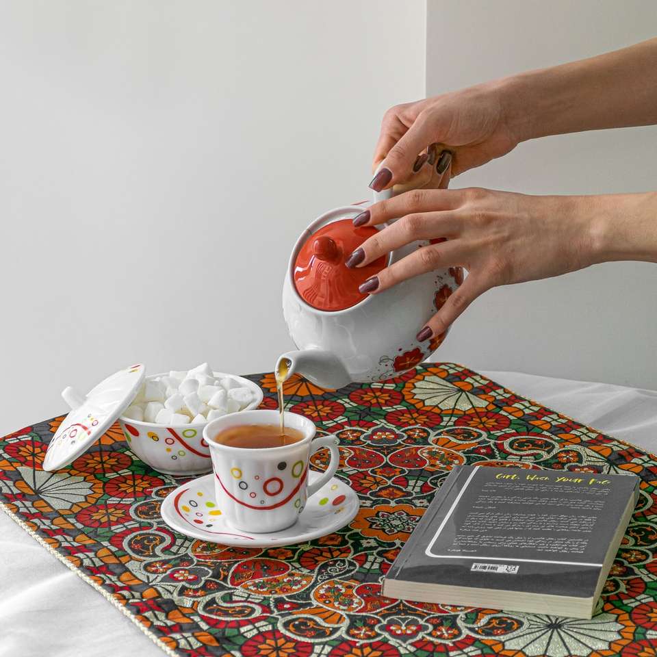 Persona che tiene tazza in ceramica rossa puzzle online
