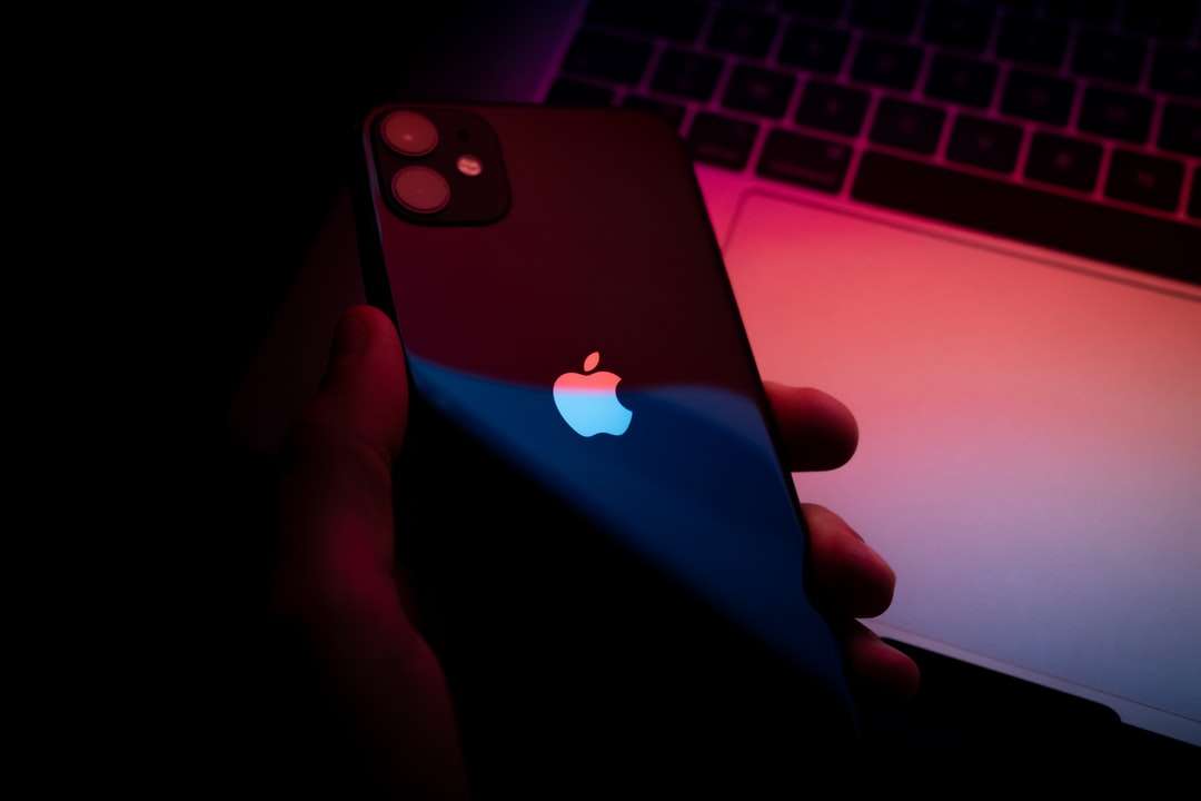 Persona que sostiene iPhone con caja azul rompecabezas en línea