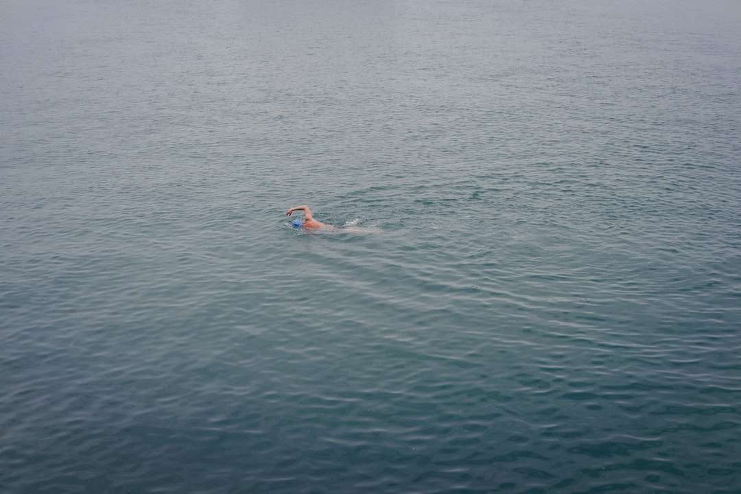 човек в синьо-бели шорти, плуващ в морето онлайн пъзел