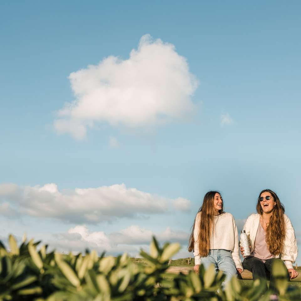 3 γυναίκες που στέκονται στο πράσινο γρασίδι κάτω από το γαλάζιο του ουρανού παζλ online
