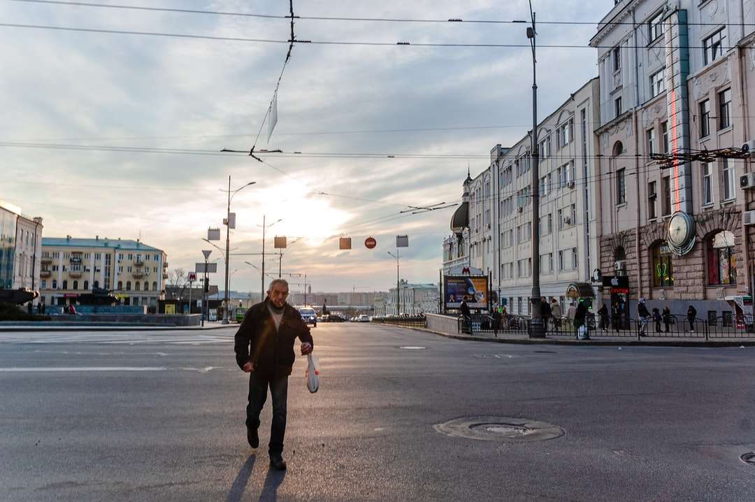 Mann in der schwarzen Jacke und der schwarzen Hose, die auf Bürgersteig gehen Puzzlespiel online
