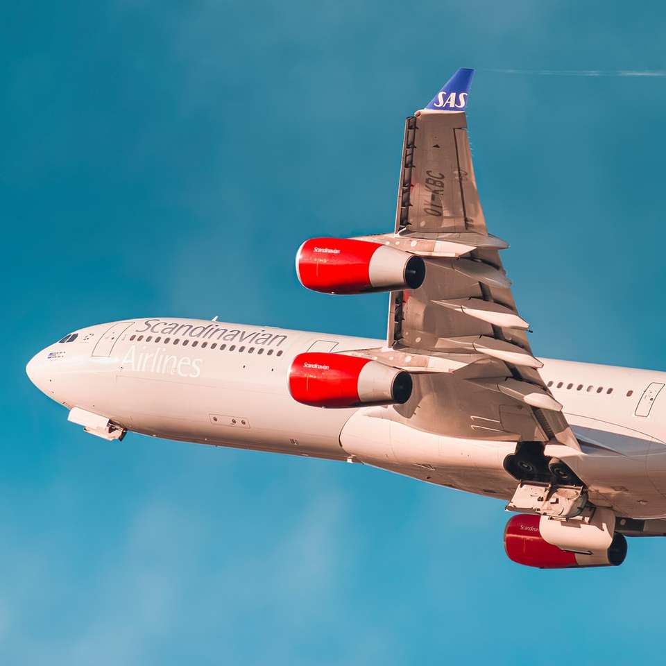 Бял и червен пътнически самолет в полет онлайн пъзел