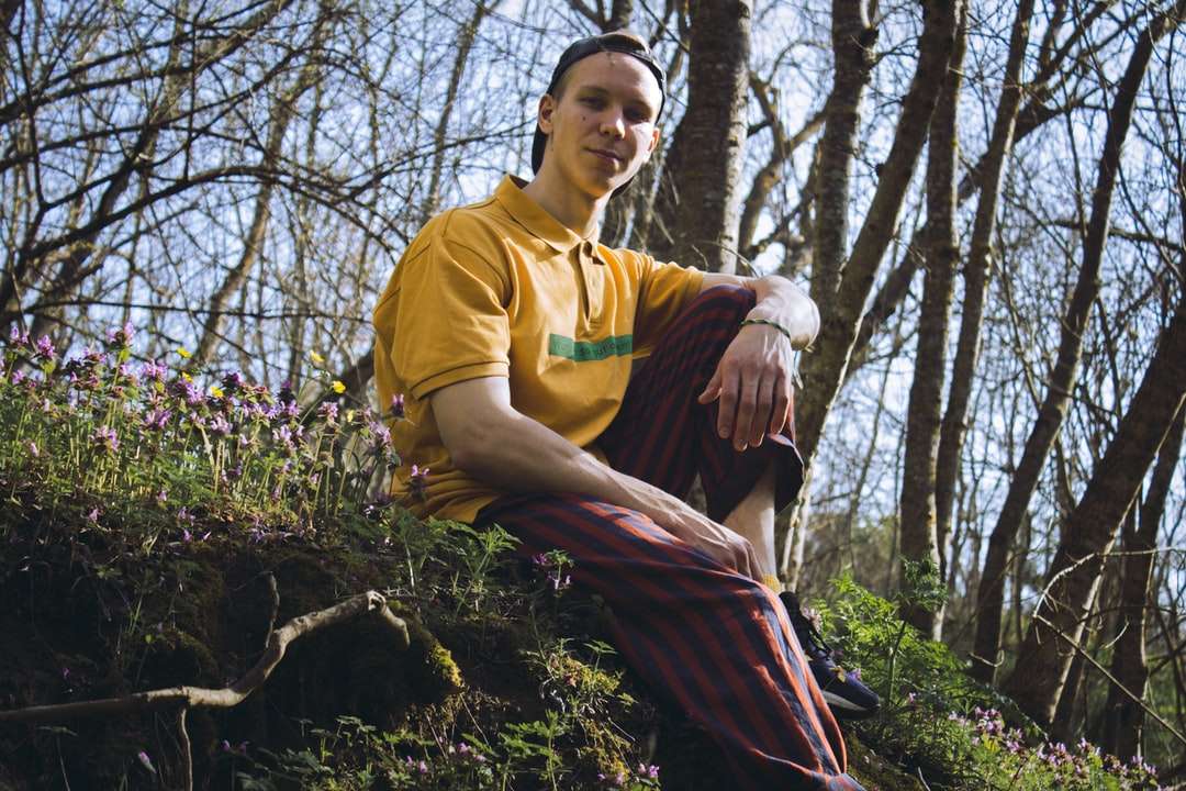 muž ve žlutém tričku s výstřihem stojící poblíž stromů online puzzle