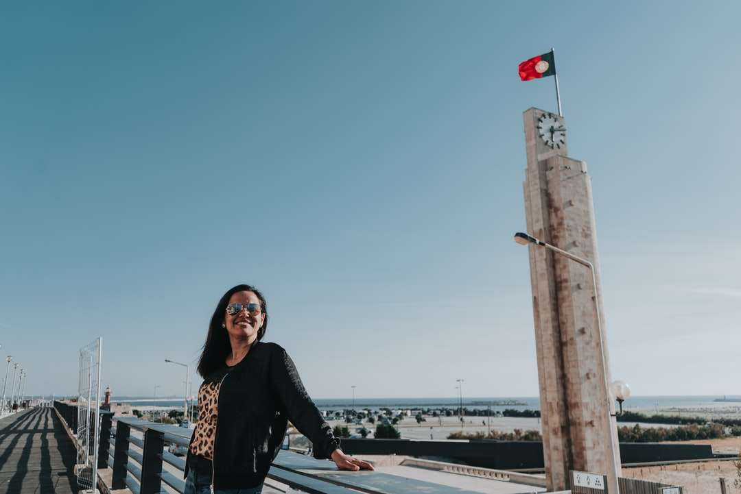 жінка в чорній сорочці з довгим рукавом стоїть на мосту пазл онлайн