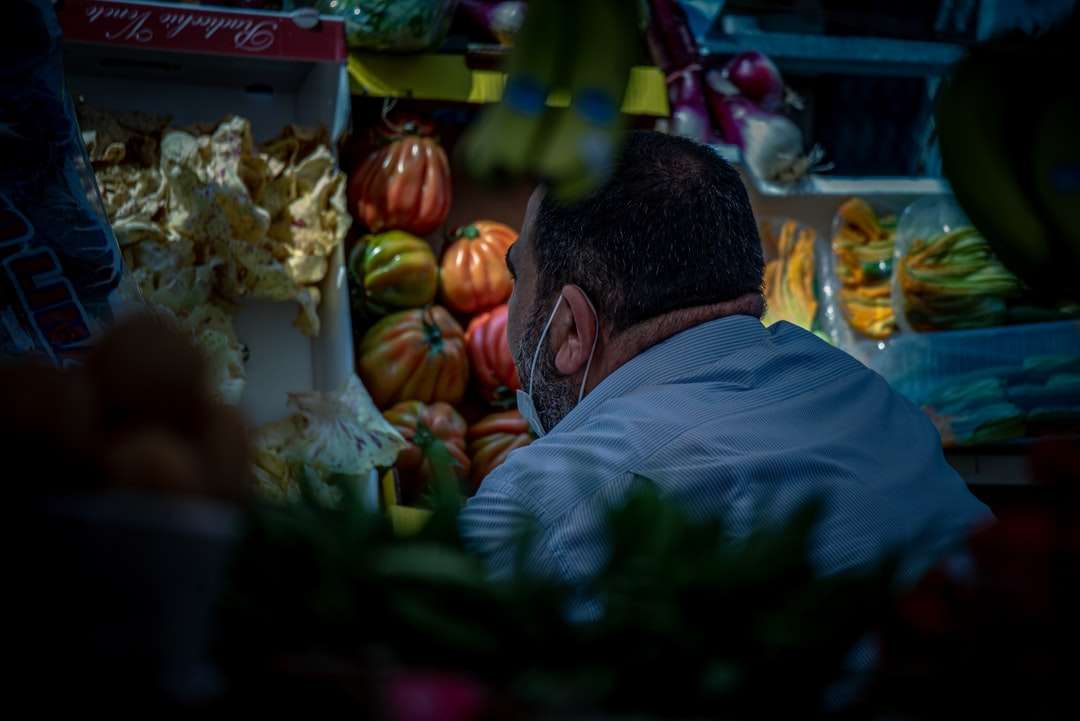 Mann im grauen Hemd, der in der Nähe der Gemüseausstellung steht Online-Puzzle