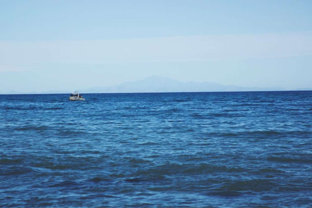 Λευκή βάρκα στη θάλασσα κατά τη διάρκεια της ημέρας παζλ online