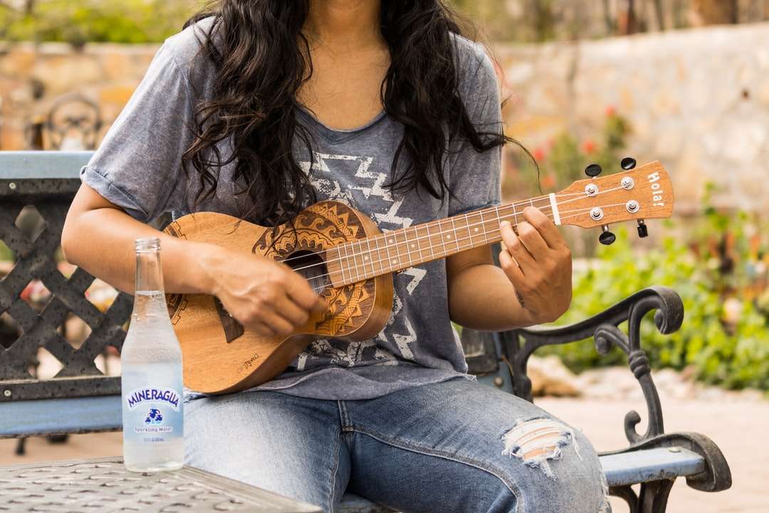 женщина в коричневой рубашке с длинным рукавом играет на акустической гитаре онлайн-пазл