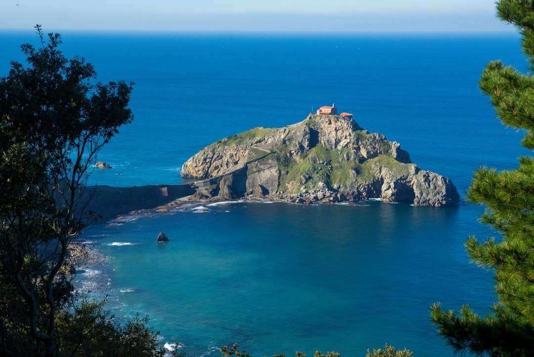 зелена и кафява планина до синьо море през деня онлайн пъзел