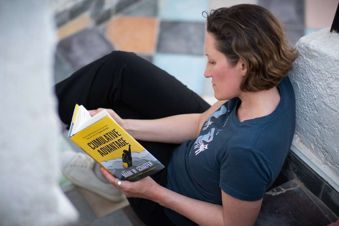 mulher de camiseta azul com gola alta segurando o livro puzzle online