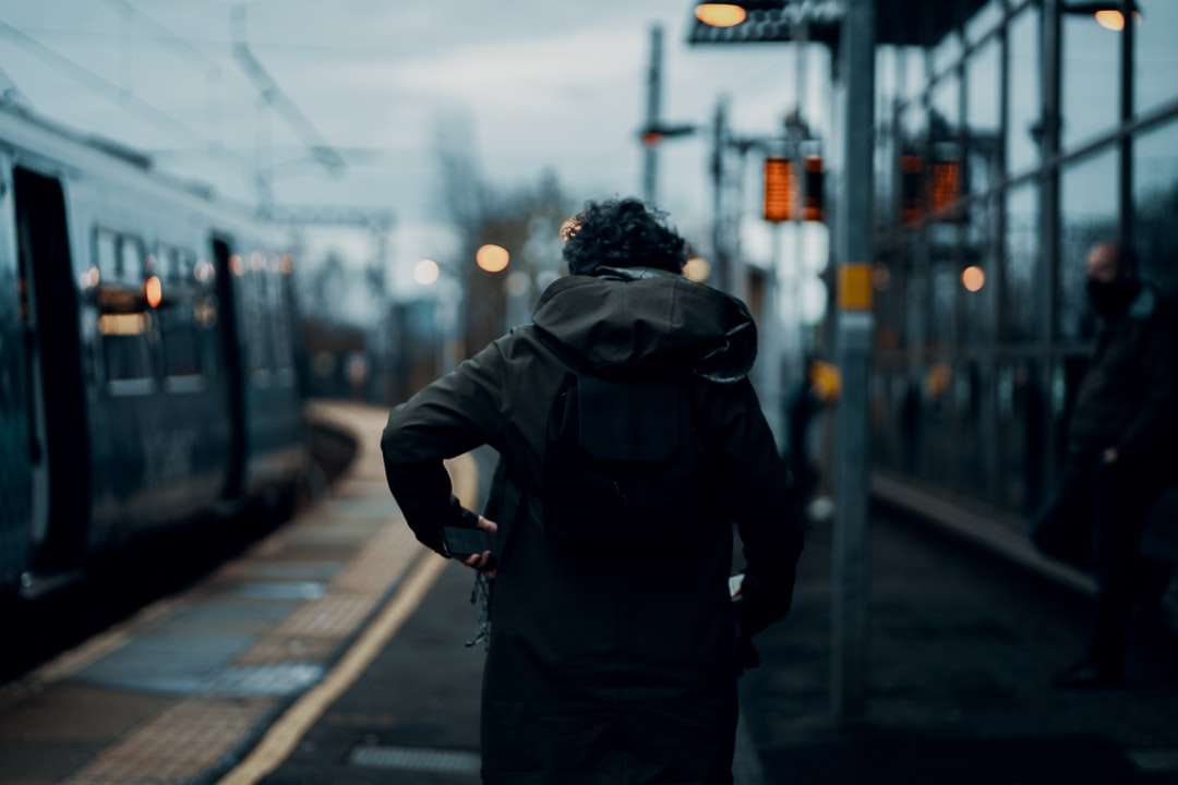 Mann in der schwarzen Jacke, die tagsüber auf Bürgersteig geht Online-Puzzle