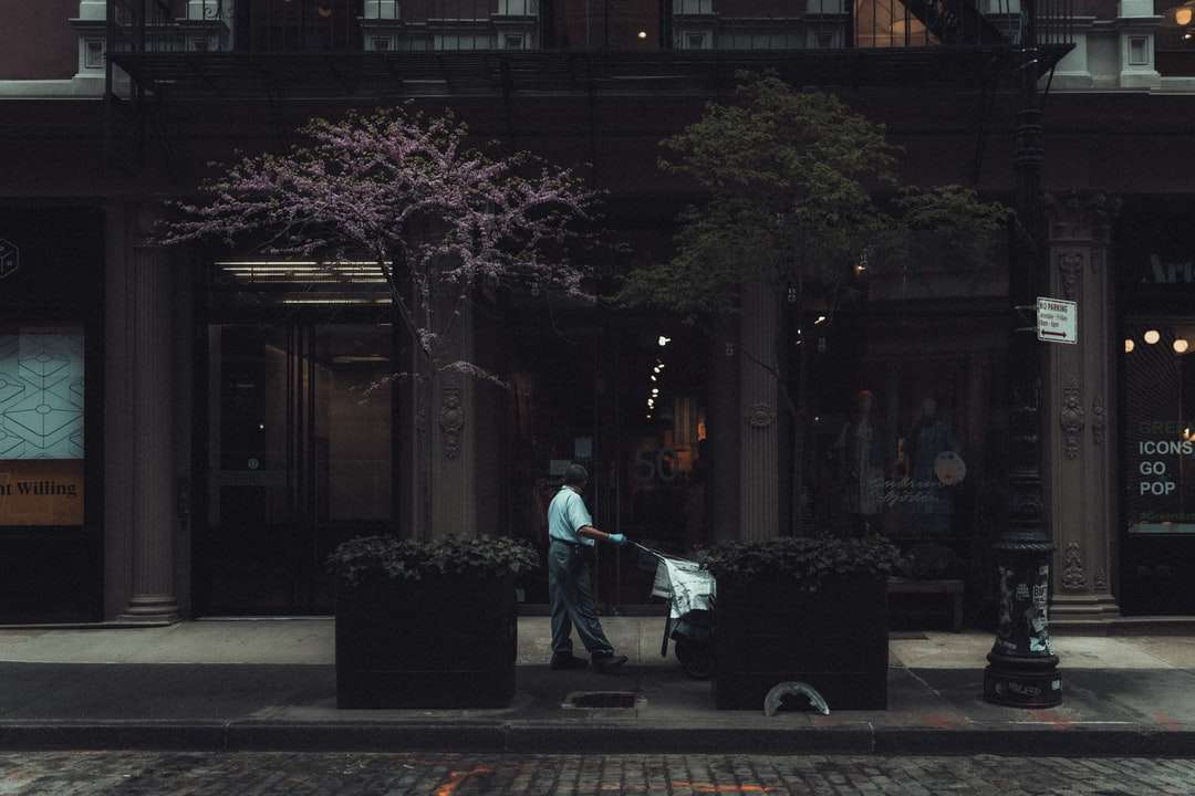 homem de jaqueta azul e calça preta andando na calçada quebra-cabeças online