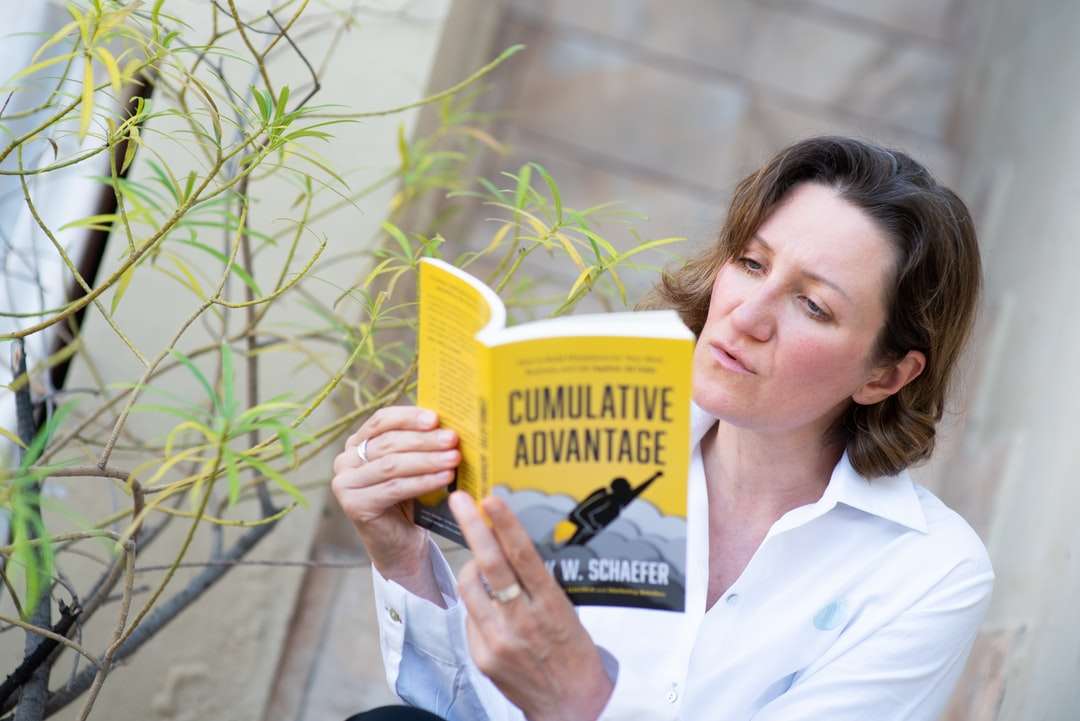 Mujer en botón blanco para arriba camisa con libro amarillo rompecabezas en línea