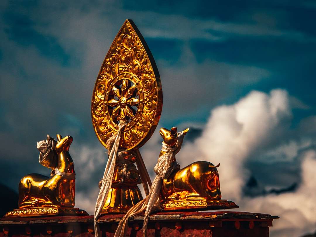 Statua del drago dell'oro e dell'oro sotto il cielo nuvoloso durante il giorno puzzle online