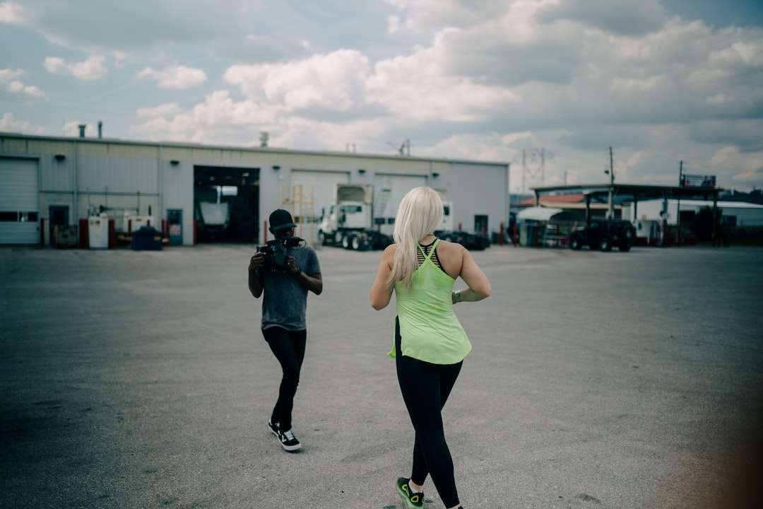 γυναίκα με πράσινο φανελάκι και μαύρα κολάν στέκεται στο δρόμο online παζλ