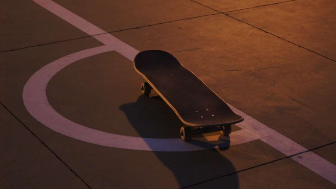 skateboard noir sur sol en béton noir puzzle en ligne