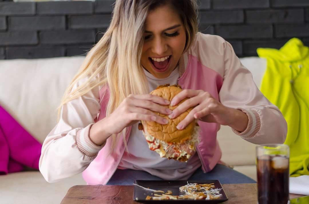 chica con camisa rosa de manga larga comiendo pan rompecabezas en línea