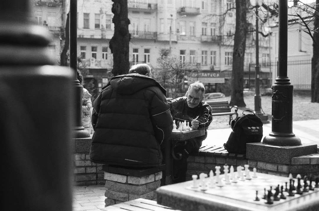 foto in scala di grigi di un uomo e una donna seduti su una panchina puzzle online