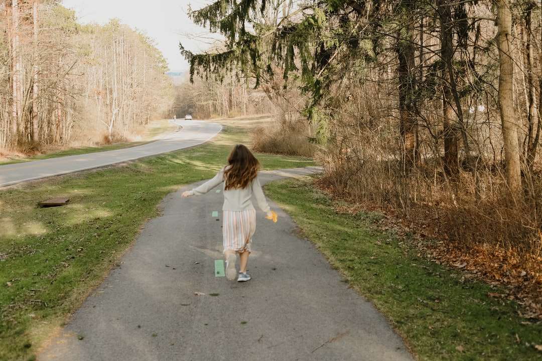 Chica en camisa blanca caminando en gris asfalto carretera rompecabezas en línea
