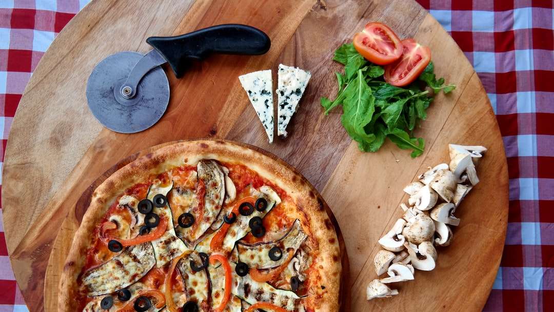 Pizza cu frunze verzi pe masă de lemn maro jigsaw puzzle online