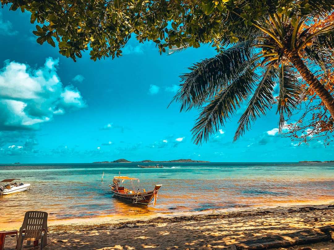 Barca marrone sulla spiaggia durante il giorno puzzle online