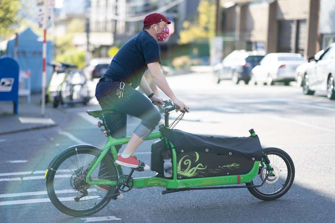 Ο άνθρωπος σε μπλε και κόκκινο πουκάμισο ιππασία πράσινο ποδήλατο παζλ online