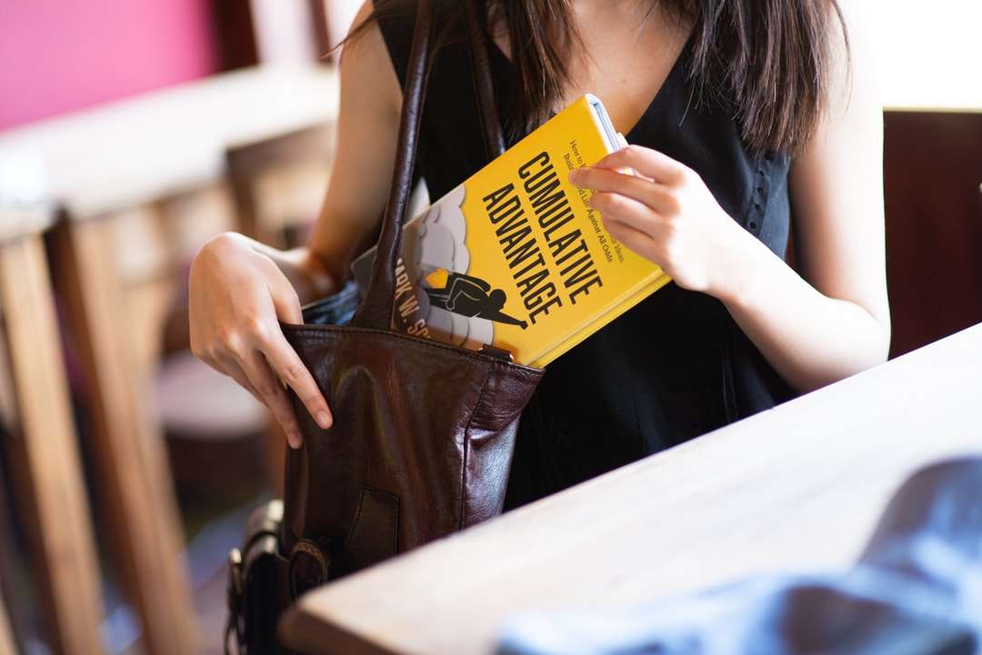 vrouw in zwart leren vest met gele en witte doos legpuzzel online