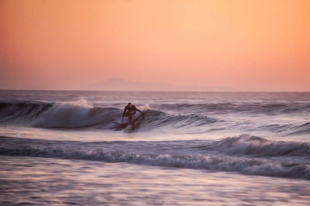 людина займається серфінгом на морських хвилях у денний час онлайн пазл