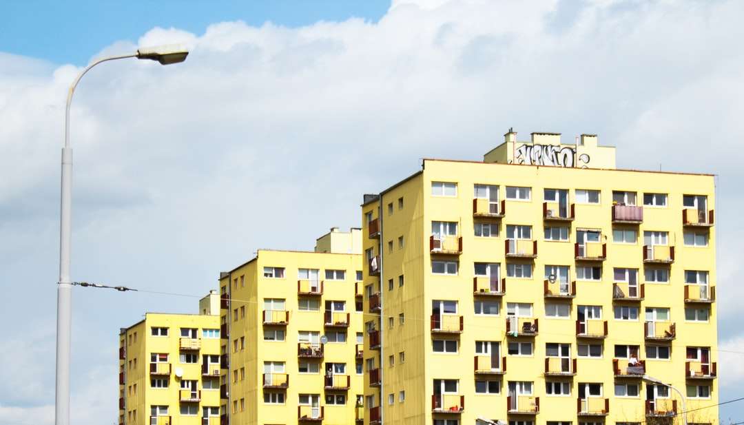 Edificio de concreto amarillo y marrón bajo el cielo azul. rompecabezas en línea
