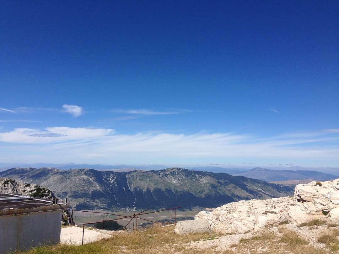 кафяви и зелени планини под синьо небе през деня онлайн пъзел