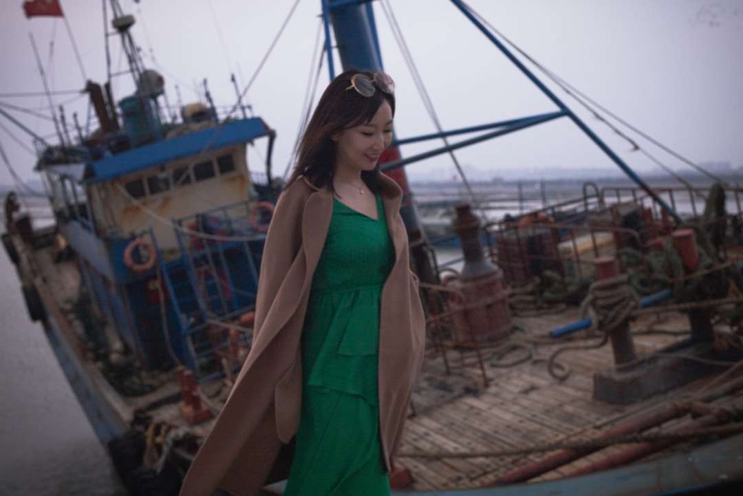 Femeie în rochie verde fără mâneci stând pe nisip maro puzzle online