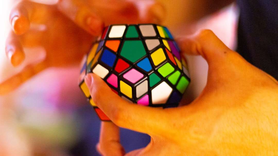 Persona que sostiene 3 x 3 Rubiks Cube rompecabezas en línea