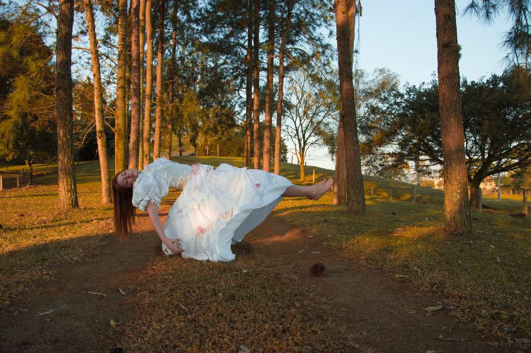 Kvinna i vit klänning som går på brun grusväg pussel på nätet