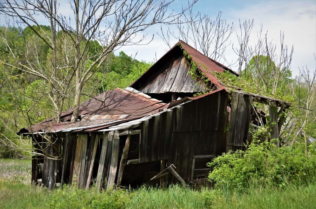 Casa de madeira marrom perto de campo de grama verde durante o dia puzzle online