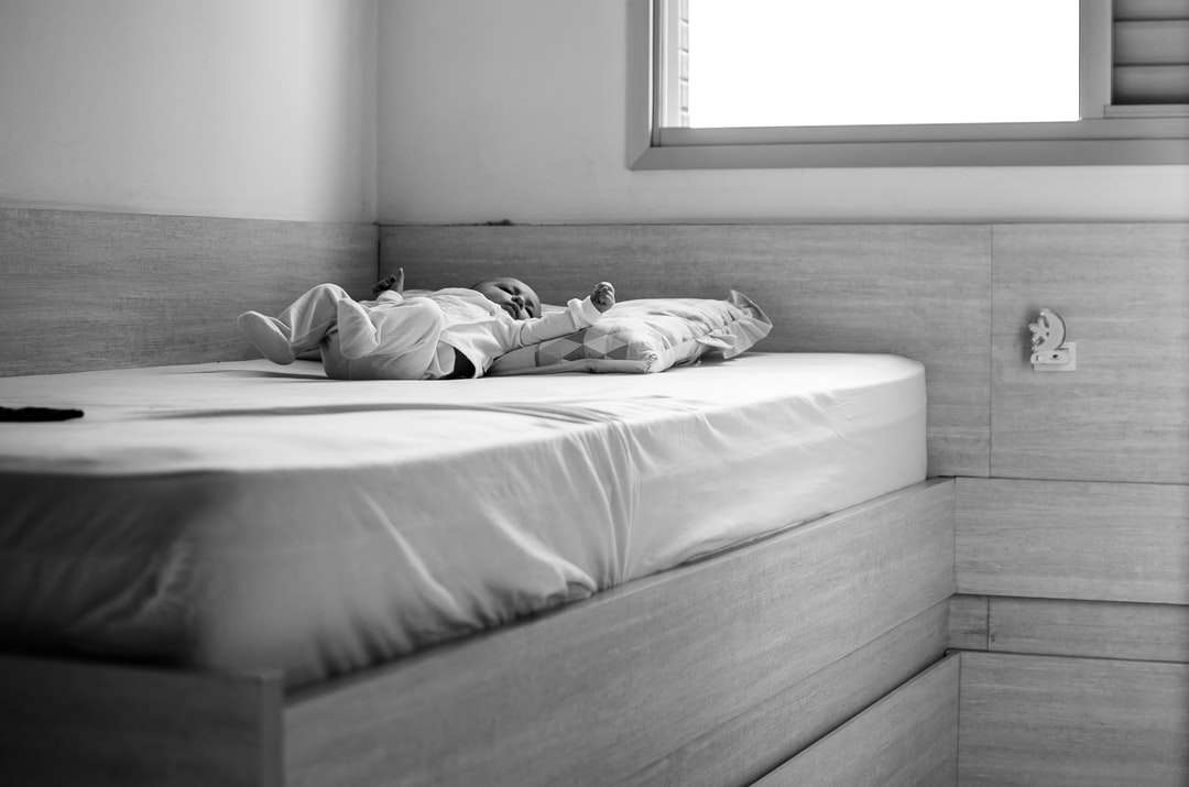 foto en escala de grises de una mujer acostada en la cama rompecabezas en línea